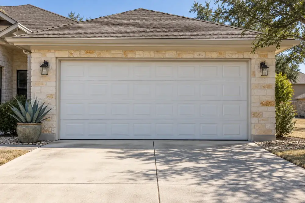 Closed white raised-panel garage door with straight sections and a black bottom seal