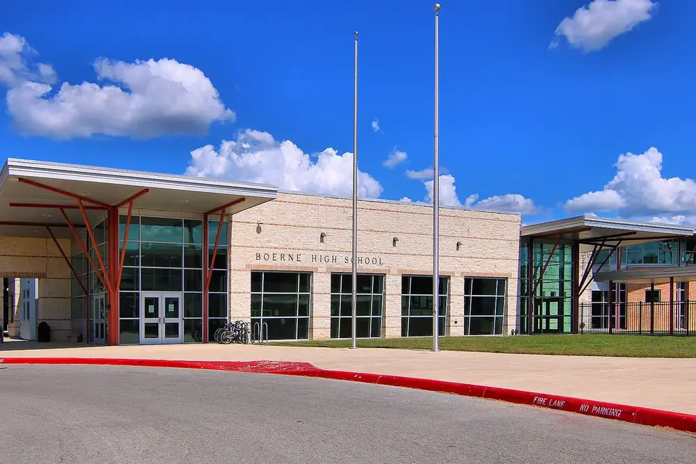 The stone and glass entrance of Boerne High School under a bright summer sky in Boerne, Texas