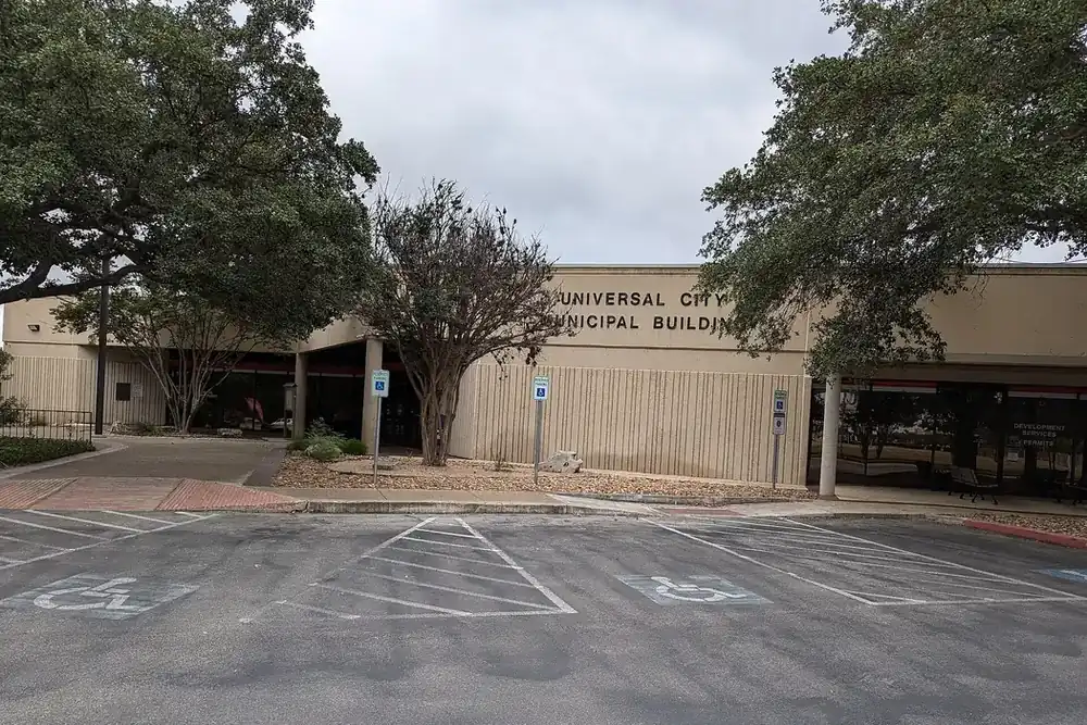The Universal City Municipal Building among large live oak trees in Universal City, Texas